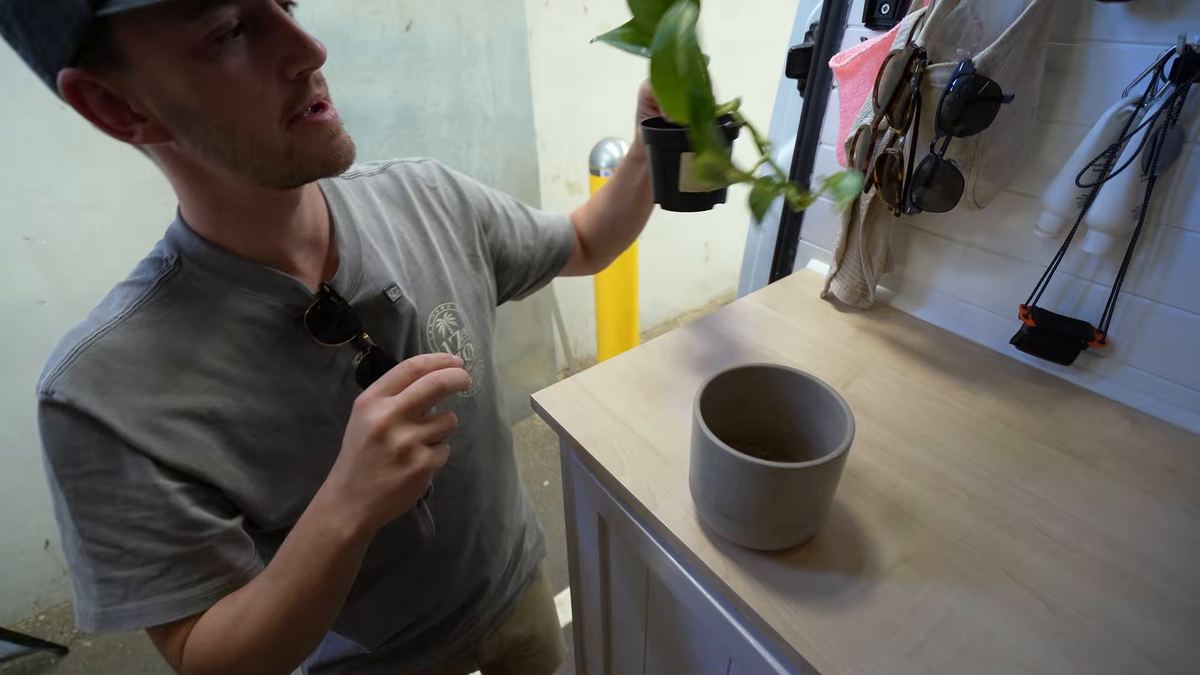 Luke lifting a potted plant out of the van before boarding